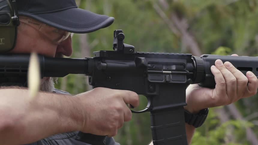 A man fires an assault rifle in slow motion