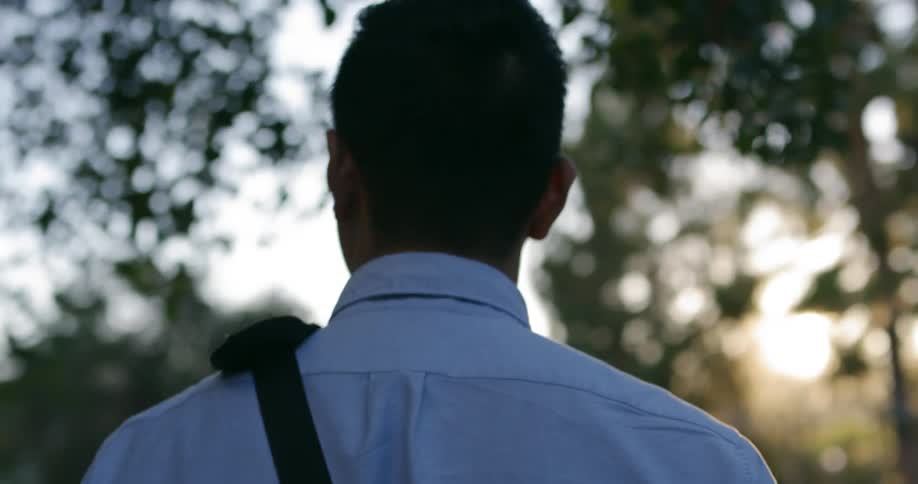 A man walks along carrying a bag