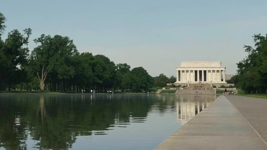 The national mall seen from ground level across the reflecting pool on a clear day