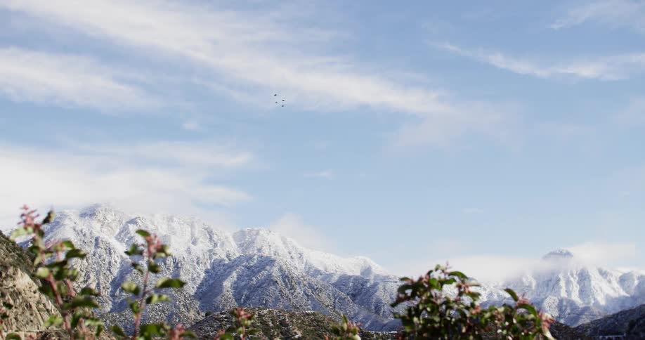 Large mountains are covered in snow on a cloudy day