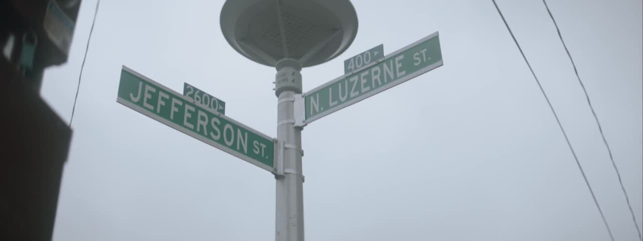 Street signs stand on a street corner in a city