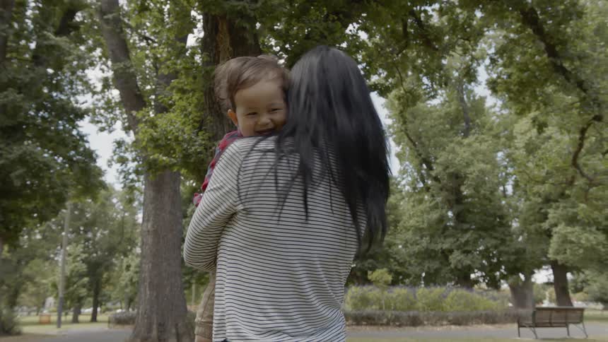 A woman holds and plays wither her child