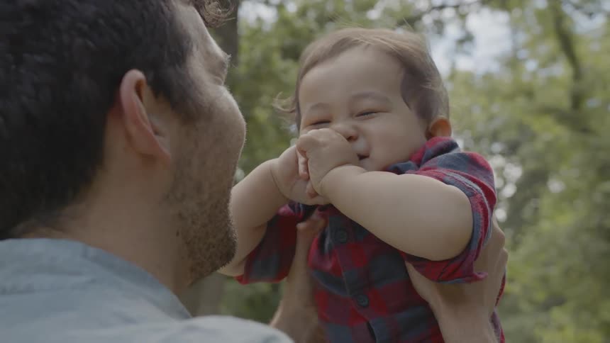 A man raises his son in the air