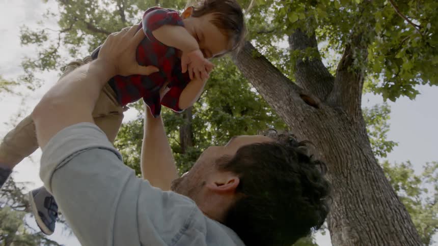 Man throwing a child in the air then catching