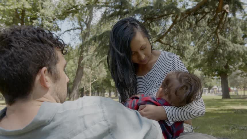 A woman nurses a baby outdoors