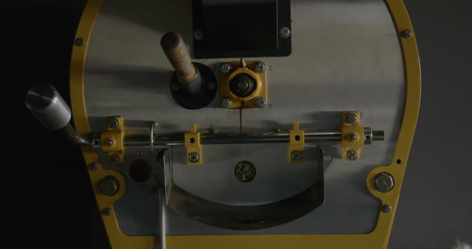 A silver and yellow machine with beans moving inside