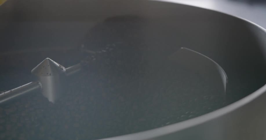 A machine stirs coffee beans