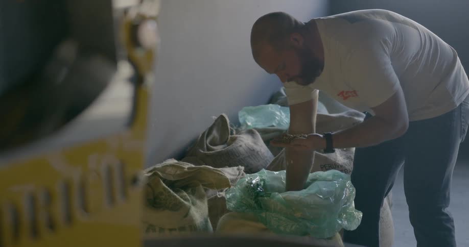 Man smelling coffee beans at the warehouse