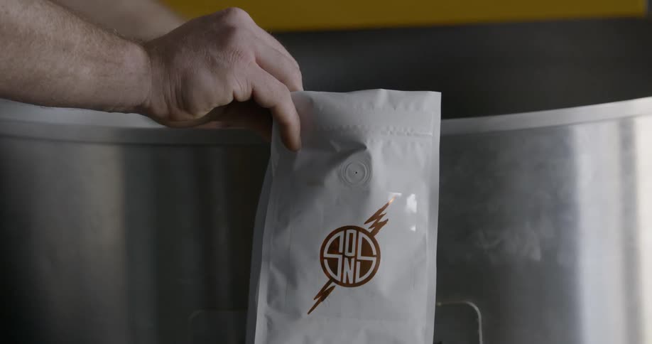 Man filling a bag with coffee beans