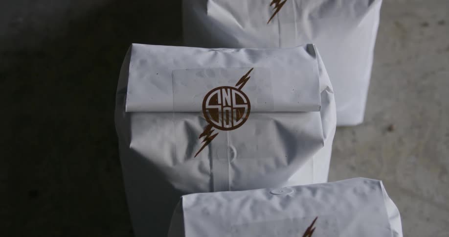 White paper bags rolled close and sealed with logo