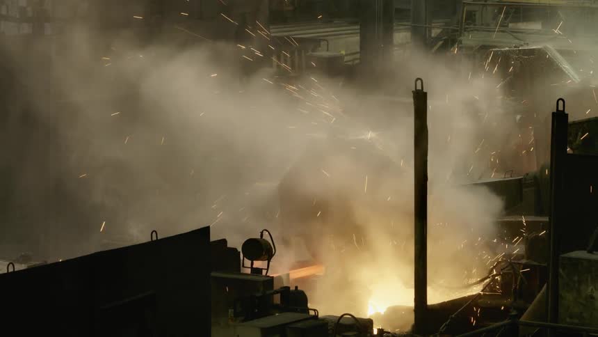 Smoke rises from a foundry with molten steel