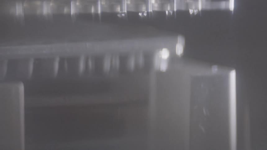 Plastic containers are stacked together in a blurry area