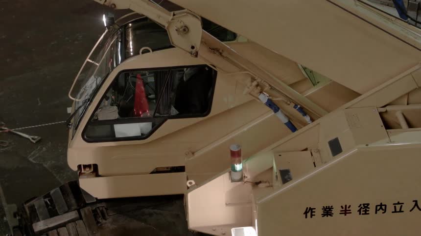 A crane slowly rises while a light rotates and shines