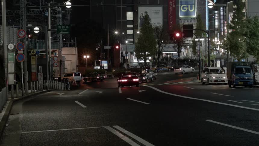 Cars driving down a city street at night