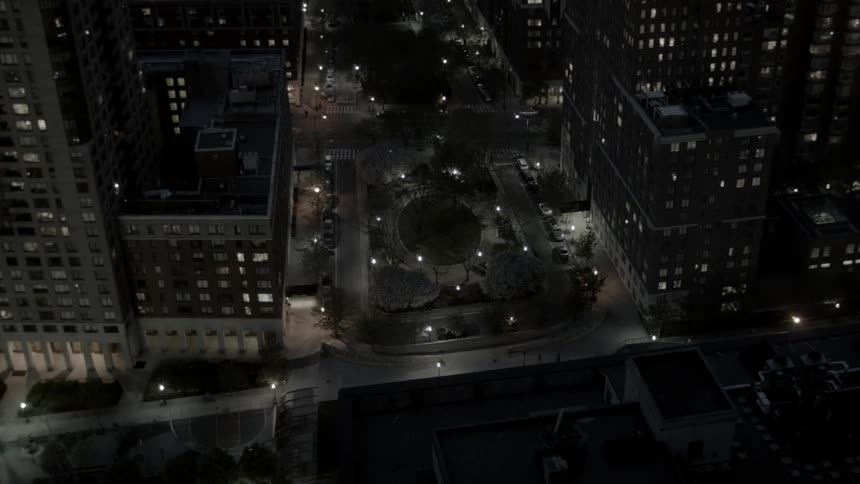 An aerial view of city buildings and streets at night