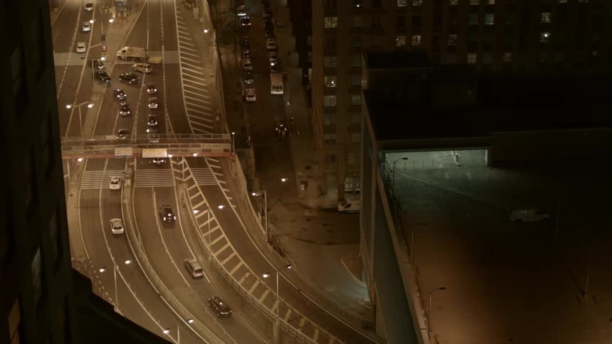 Traffic zips through a busy roadway in a city