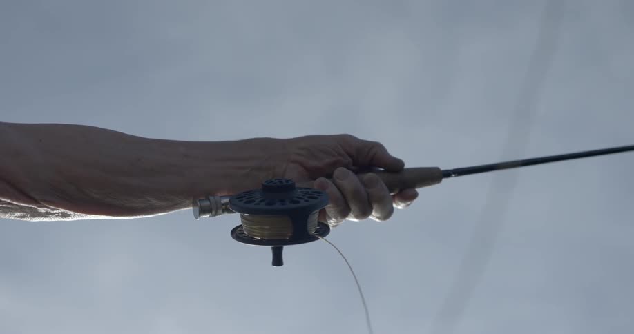 A person is casting his fishing line on a cloudy day