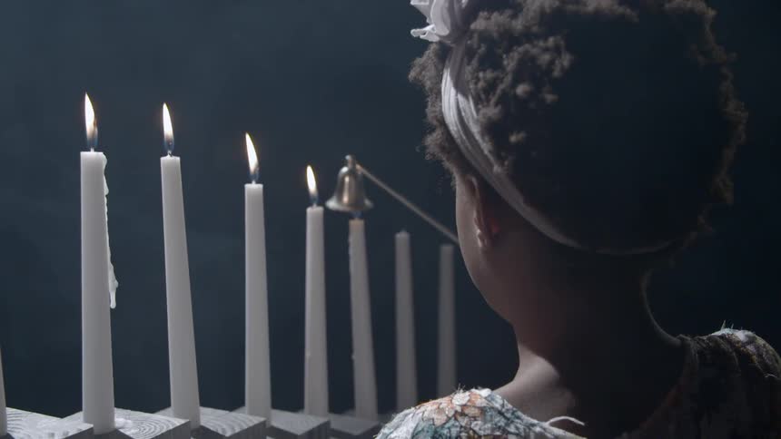 A little girl snuffs out a candle