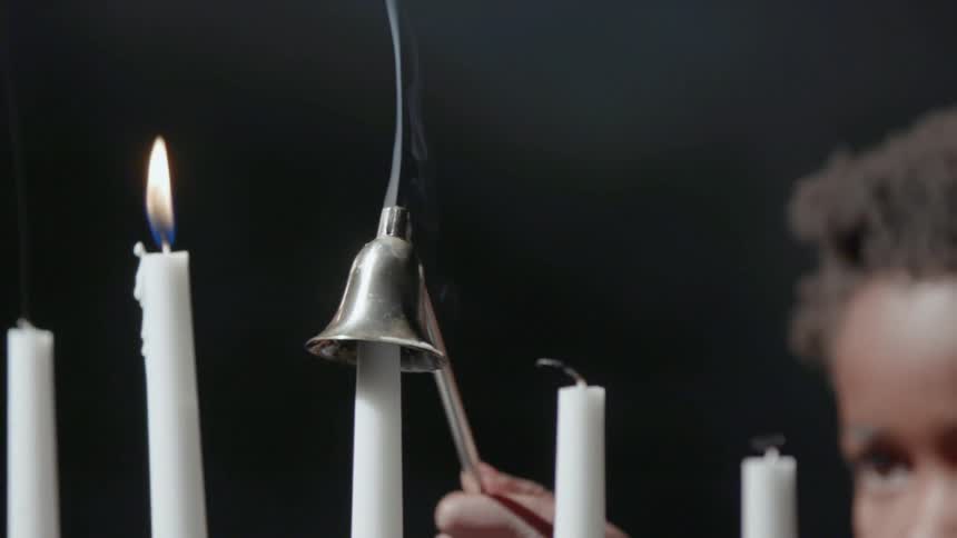 Child quenches candle in candelabra