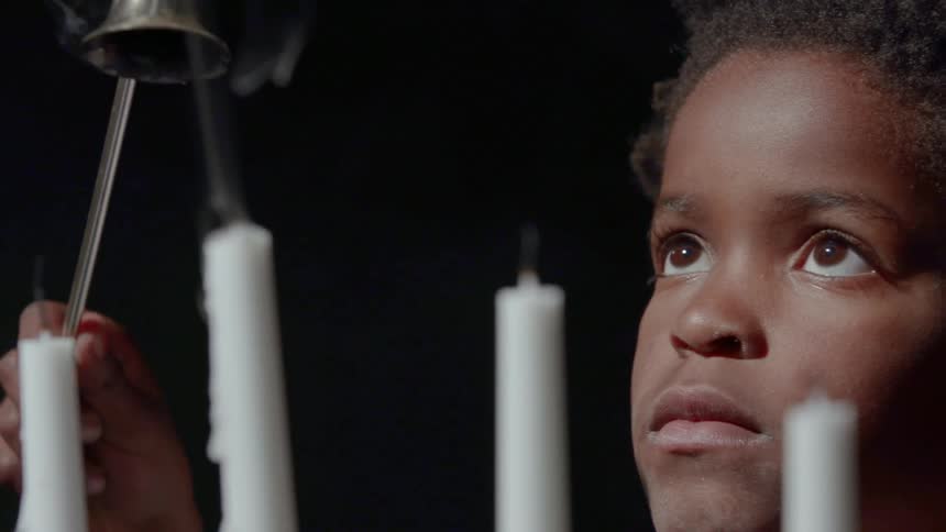 A child extinguishes a candle