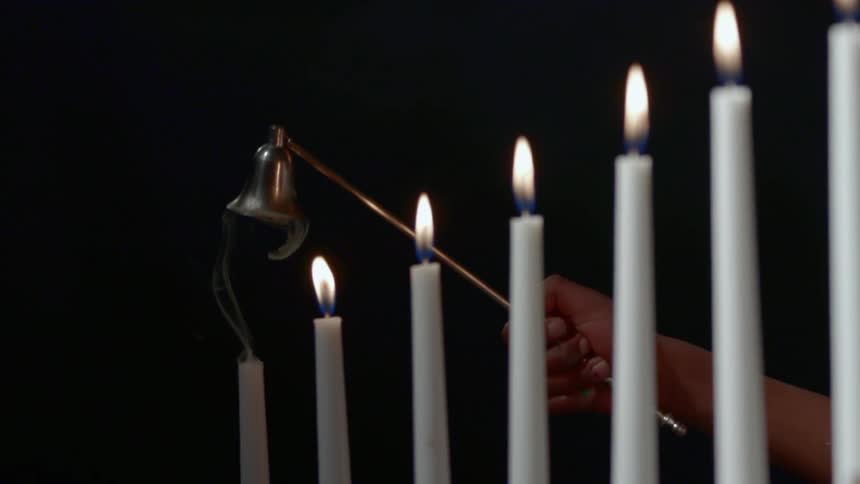 A person extinguishes a candle