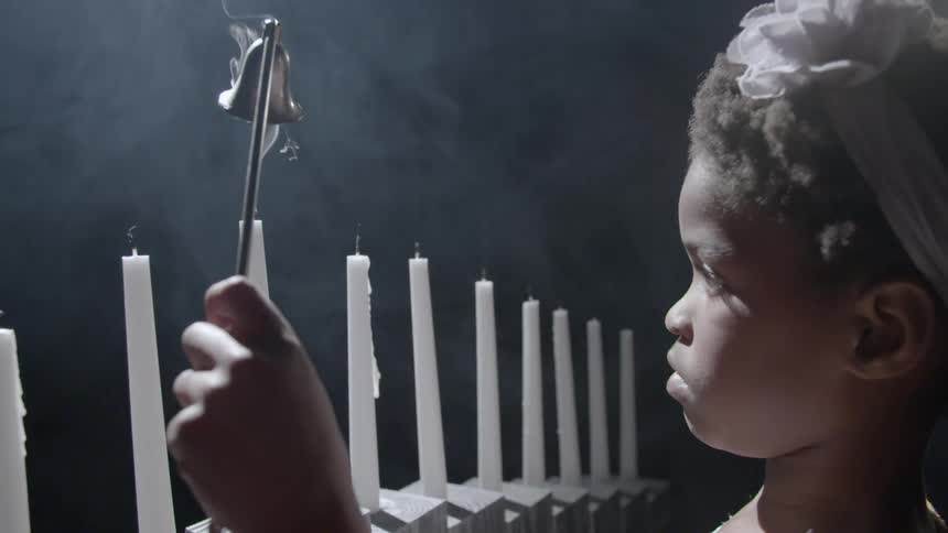 A child is putting out candles in a church
