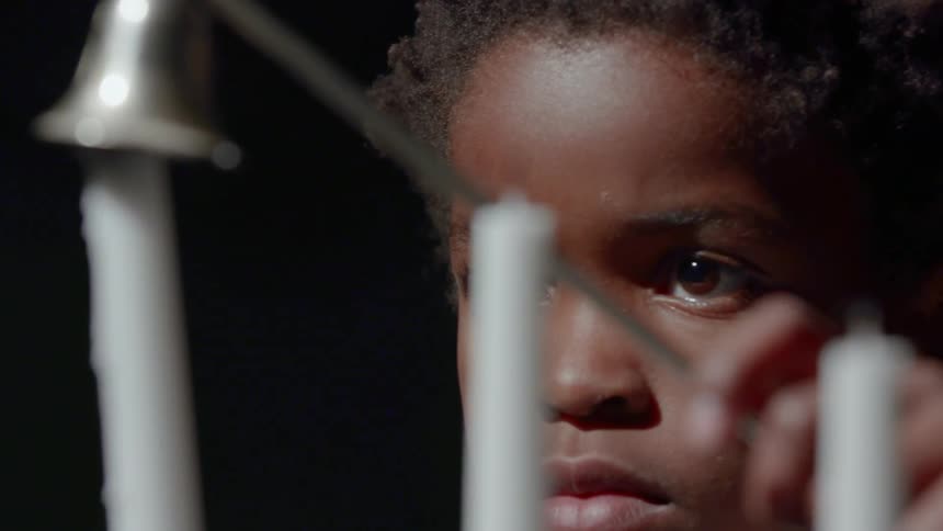 A child is putting out candles
