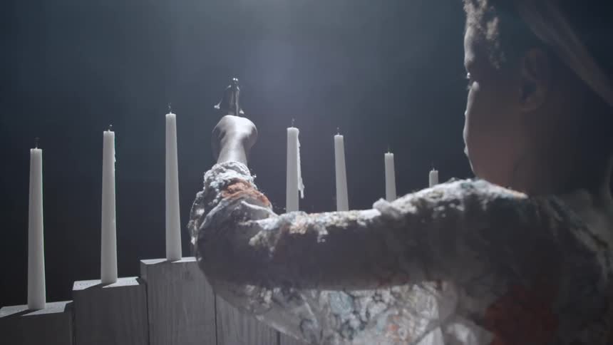 A girl extinguishing a tenebrae candle with a candle snuffer