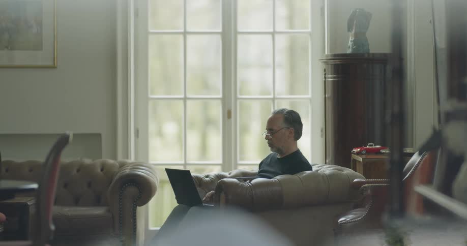 A man is typing on a laptop indoors