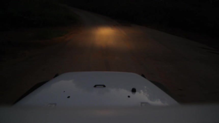 POV shot of jeep on dirt road at dusk