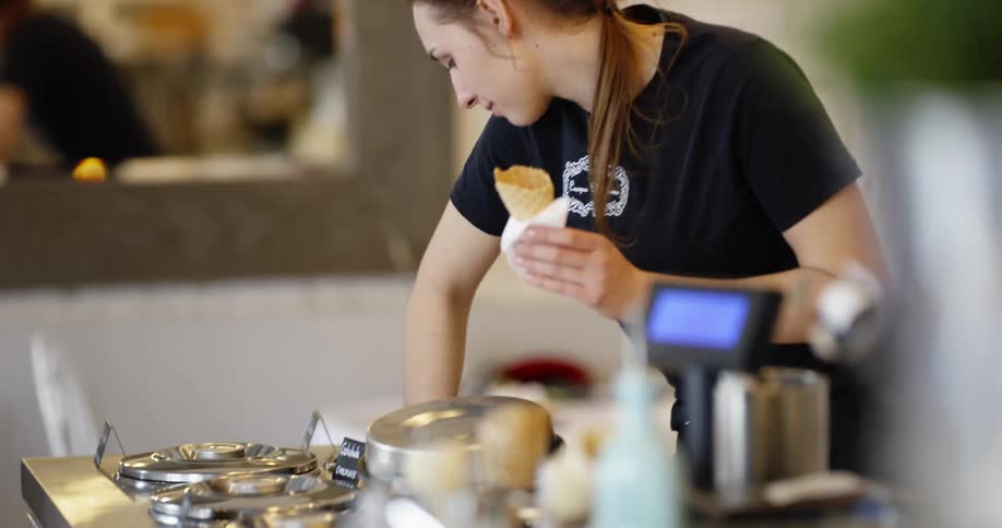 A woman is serving ice cream in a shop