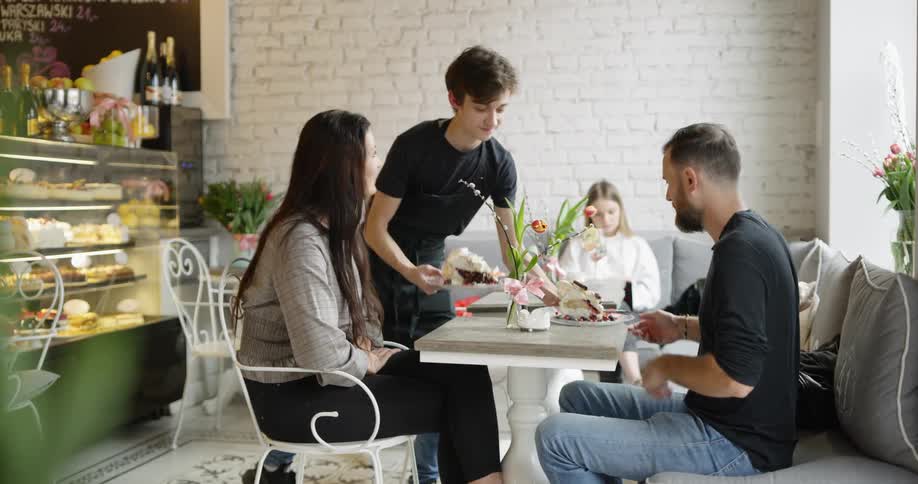 A couple seated in the restaurant are served dessert
