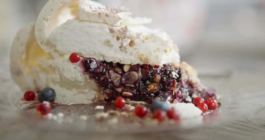A creamy dessert with berries sits on a glass plate