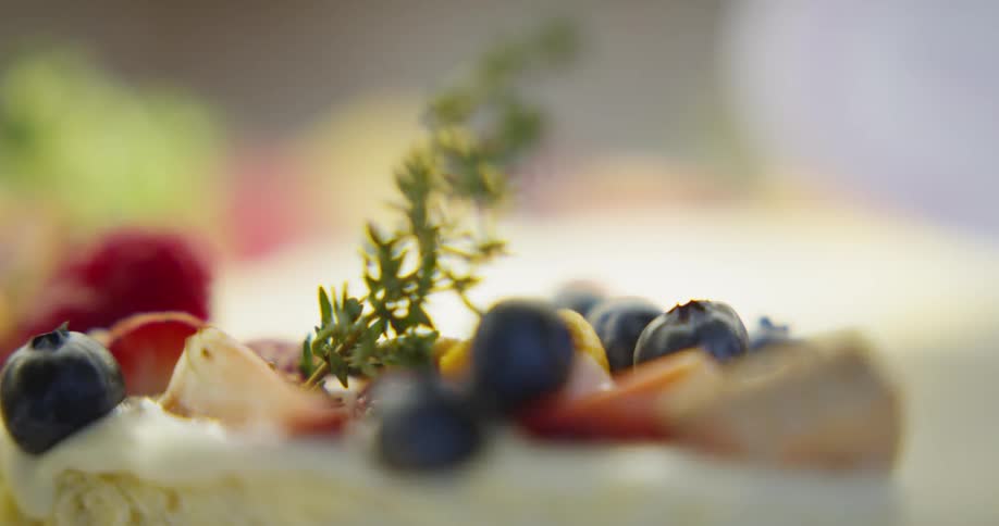 Blueberries and strawberries sit atop an iced cake