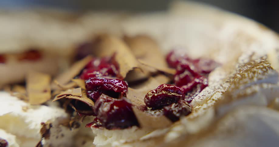 A pie topped with whipped cream cinnamon and cranberries