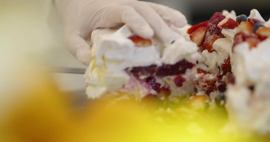 A worker removes a piece of fruit cream pie