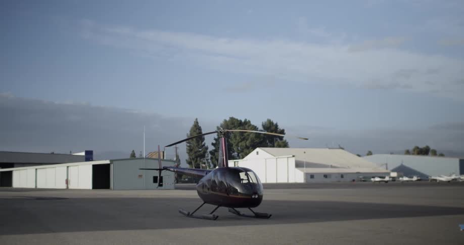 A helicopter sits on an airport tarmac