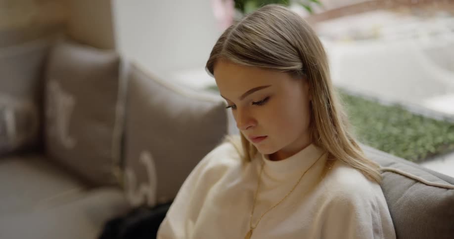 A woman sits on a couch reading a book