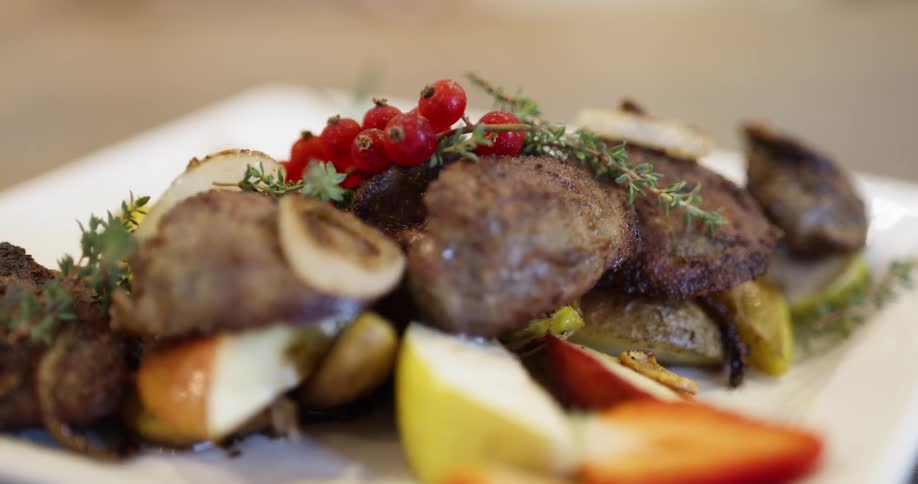 Nicely presented gourmet meal of beef and vegetables on white plate
