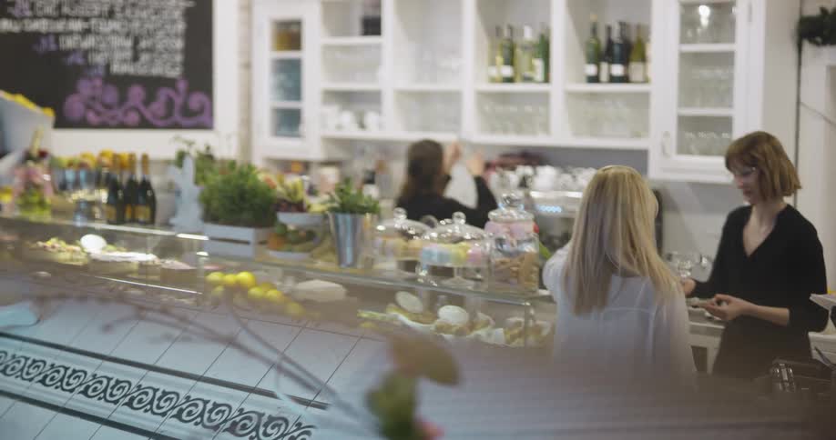 A blonde woman orders a drink at a restaurant