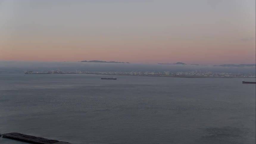 An aerial view of ships off the coast at dawn