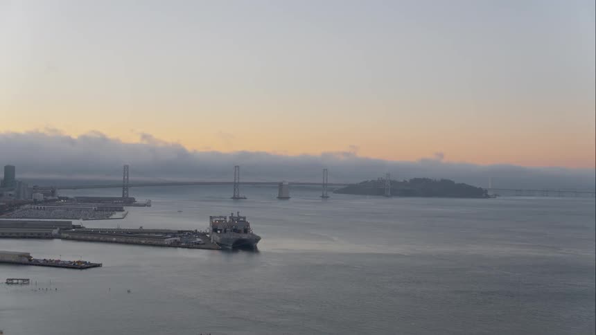A bridge and urban area are illuminated as the sun rises