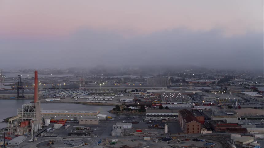 A large shipping yard on the coast of a city in the evening
