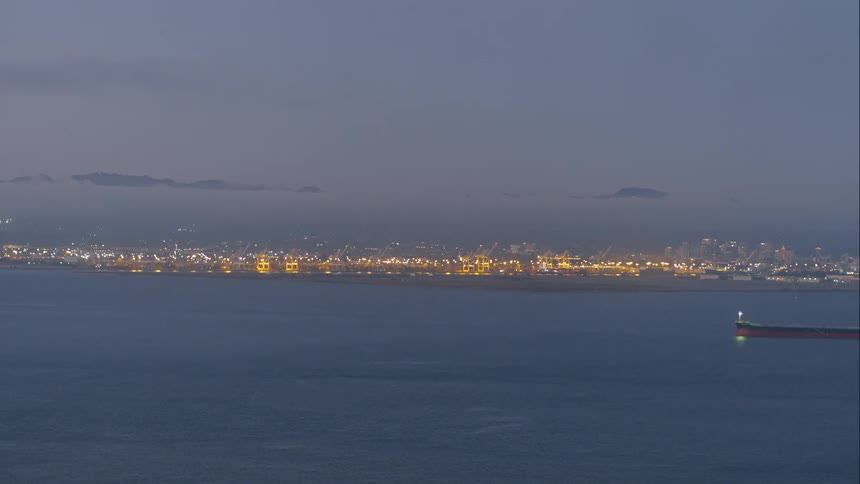 The skyline is lit up with lights in the horizon