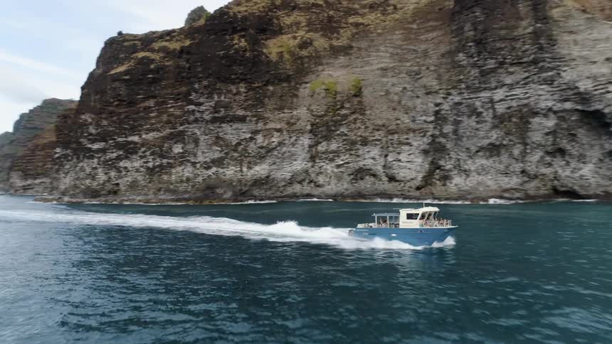 A boat sailing near the mountain cliff