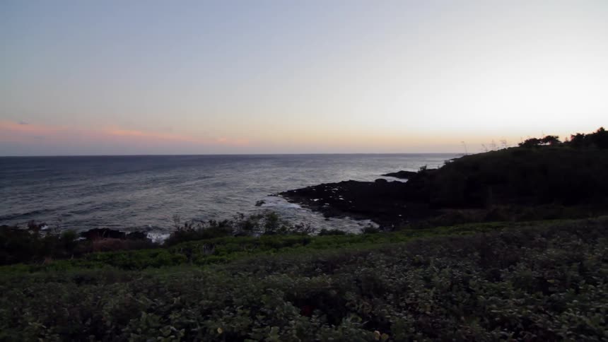 Ocean waves wash ashore a beach at sunset
