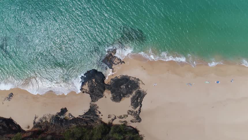 An aerial view of a sea shore and blue ocean