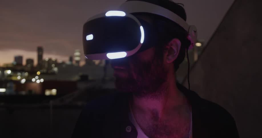 A man uses a virtual reality headset in a city at night