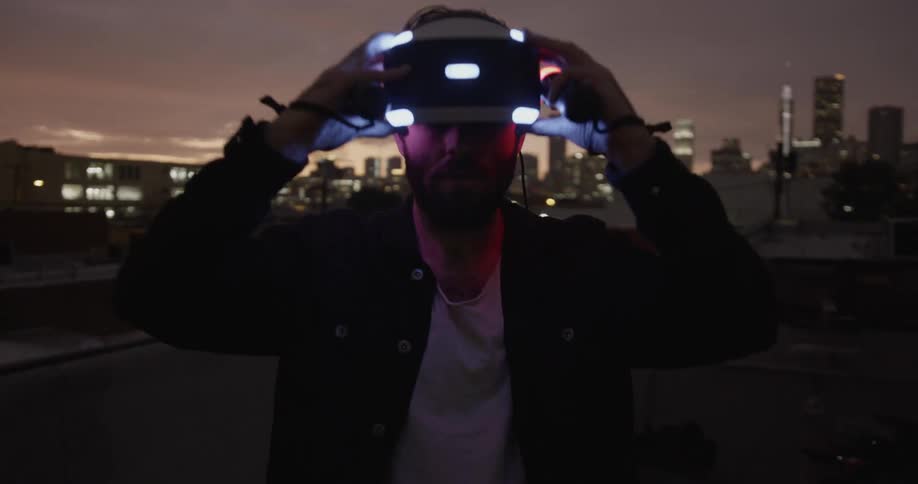 A person takes off a vr headset on the roof of a building