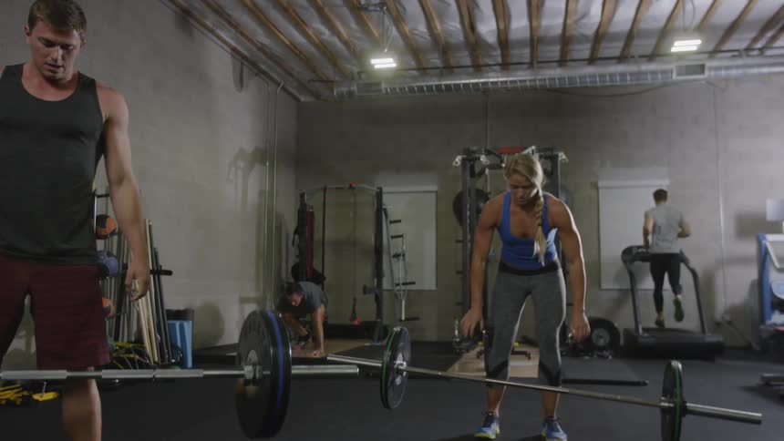 A woman and three men exercise at a gym